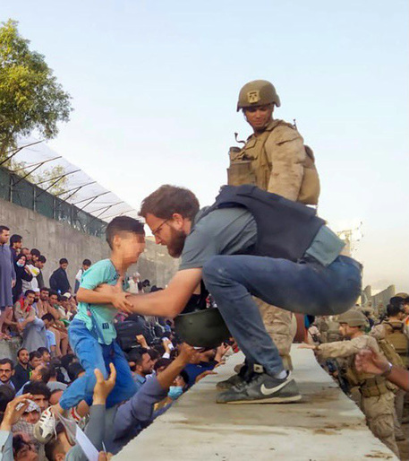 Console italiano aiuta bimbo in scalo di Kabul, la foto diventata virale