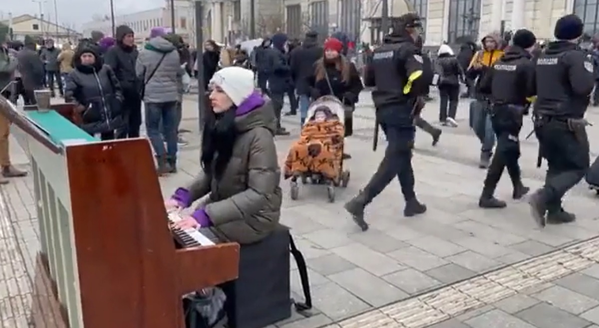 Ucraina, la ragazza che suona “note di pace” alla stazione, tra la gente in fuga