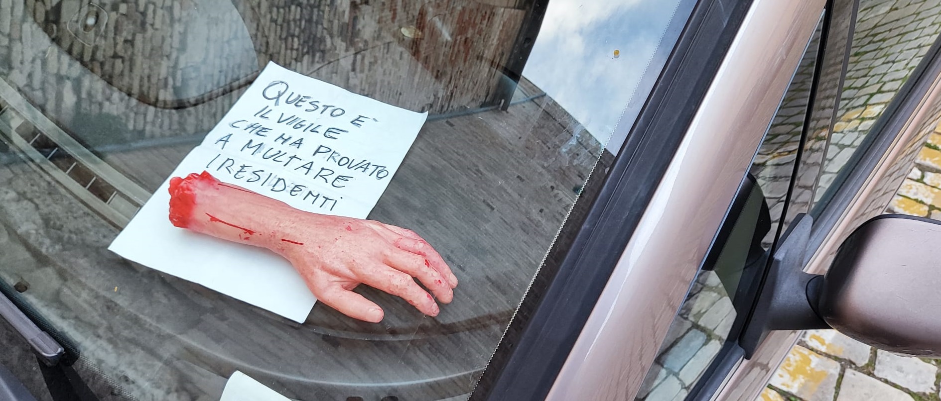 Macabro atto contro la polizia locale: scritta shock e braccio mozzato su cofano auto